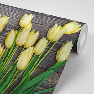 Fototapeta žlté tulipány na drevenom podklade