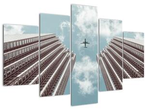 Obraz lietadla medzi budovami (150x105 cm)
