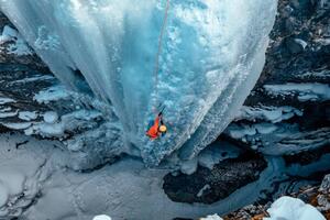 Umelecká fotografie A woman ice climbs up a, Alex Ratson, (40 x 26.7 cm)