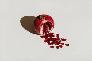 Umelecká fotografie ut pomegranate on a white background., Tanja Ivanova, (40 x 26.7 cm)