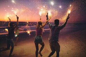 Umelecká fotografie Friends running on a beach with fireworks, wundervisuals, (40 x 26.7 cm)