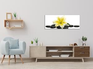 Obraz sklenený kvety žltej ľalie a čierne kamene okruhliaky - 30 x 60 cm