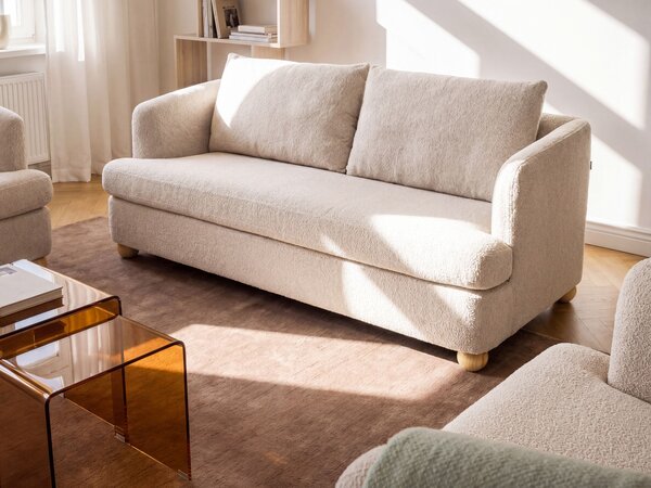 3-miestna pohovka béžová buklé čalúnenie guľaté drevené nohy bočné opierky obývacia izba moderný minimalistický štýl