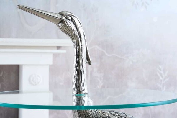 Estila Dizajnový okrúhly príručný stolík Ardea so skulpturálnou podstavou v tvare volavky v striebornej farbe 88 cm