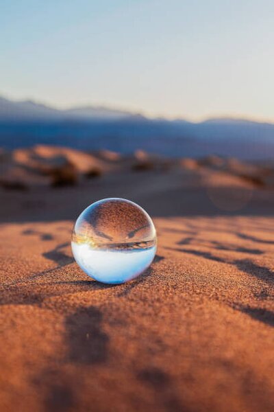 Umelecká fotografie Glass Sphere on Desert Sand, Lena Wagner, (26.7 x 40 cm)