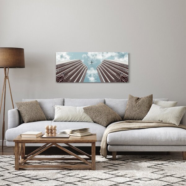 Obraz lietadla medzi budovami (120x50 cm)