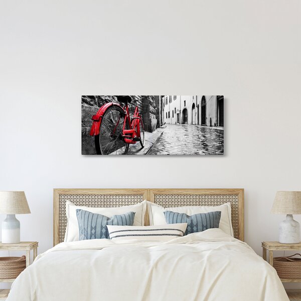 Obraz červeného kolesa na dláždenej ulici (120x50 cm)