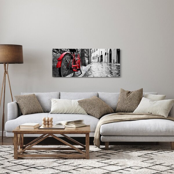 Obraz červeného kolesa na dláždenej ulici (120x50 cm)
