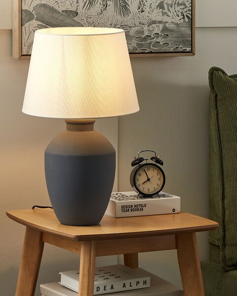 Stolná lampa sivý keramický podstavec biele ľanové tienidlo minimalistický dizajn