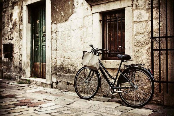 DIMEX | Vliesové fototapety na stenu Bicykel pri kamennom múre MS-5-1213 | 375 x 250 cm | čierna, krémová, hnedá